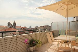 een balkon met een tafel en een parasol bij River & Ocean Studio in Porto