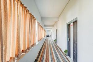 a corridor with curtains in a building at Capital O Sri Krishna Palace Near Sum Hospital in Bhubaneshwar