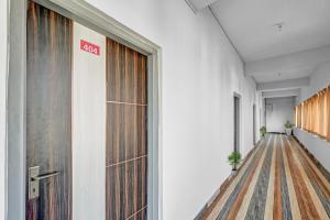 an office corridor with a exit sign on the door at Capital O Sri Krishna Palace Near Sum Hospital in Bhubaneshwar