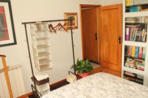 een kamer met een bed en een boekenplank bij River & Ocean Studio in Porto