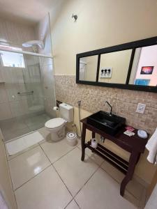 uma casa de banho com um chuveiro, um WC e um lavatório. em Hospedaria Gengibre em Barra Velha