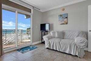 een woonkamer met een bank, een tv en een balkon bij Seahorse unit I in Pensacola Beach