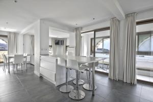 a kitchen with a table and chairs and windows at Pavillon Itsasoan in Hendaye