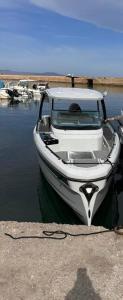 a white boat tied to a dock in the water at Villa Asteria in Melidhónion