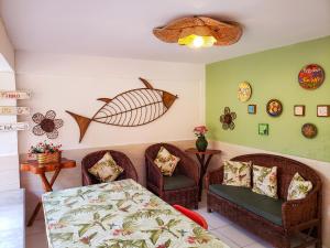 a living room with two chairs and a table and a dining room at Paranambuca Pousada in Porto De Galinhas