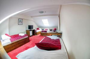 Habitación con 2 camas y sábanas rojas. en Hotel Konak Konjic, en Konjic
