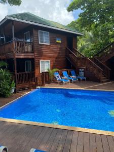 a house with a large swimming pool in front of a house at Blue Bahia Resort in Sandy Bay