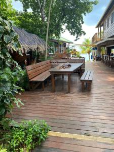 a wooden deck with a picnic table and benches at Blue Bahia Resort in Sandy Bay