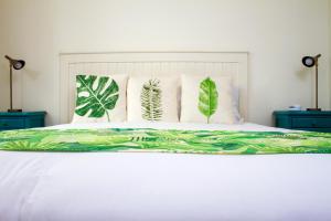 a bed with green and white sheets and pillows at Hotel Casa de la Vega in Bogotá