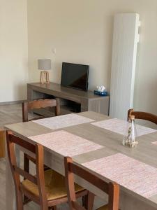 a dining room with a table with chairs and a television at Saint Georges de didonne in Saint-Georges-de-Didonne