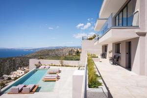 vista su una casa con piscina e sedie di Saronida Hills a Saronida
