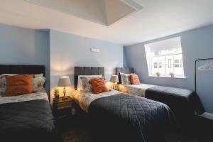 2 camas en una habitación con paredes azules en Central Brighton few Steps from Brunswick Square, en Brighton & Hove