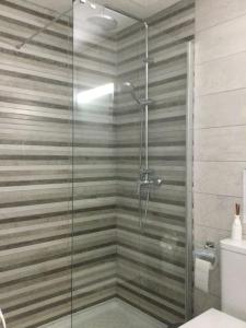 a shower with a glass door in a bathroom at Natural y sano: Charco del Palo in Charco del Palo