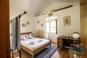1 dormitorio con 1 cama y escritorio en una habitación en Casa do Merendário, en Praia da Vitória