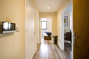 a hallway with a room with a bed and a television at Hybrid Resi - Cheam, Sutton in Cheam