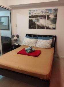 a bedroom with a large bed with a red blanket at Room at SM Bicutan with Balcony in Manila