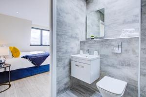 a bathroom with a sink and a toilet and a bed at Hybrid Resi - Cheam, Sutton in Cheam