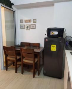 a kitchen with a table and a small refrigerator at Room at SM Bicutan with Balcony in Manila