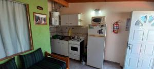 a small kitchen with a refrigerator and a stove at Cuty Nakey in Puerto Madryn