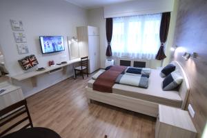 sypialnia z łóżkiem, biurkiem i telewizorem w obiekcie d.Five Premium Studio in the Center w Budapeszcie