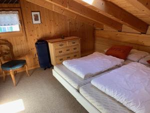a bedroom with two beds and a dresser at Grindelwald-Sunneblick in Grindelwald