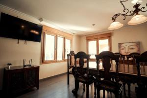 a dining room with chairs and a flat screen tv at Villa san jaime in Daimés