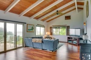 a living room with a couch and a tv at Hilo Home with Private Deck and Stunning Ocean Views! in Hilo