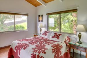 a bedroom with a bed and two windows at Hilo Home with Private Deck and Stunning Ocean Views! in Hilo