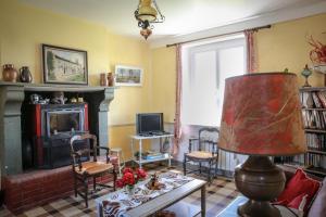 sala de estar con chimenea y TV en CRASVILLE- EN COTENTIN VUE EPOUSTOUFLANTE SUR LA MER en Crasville