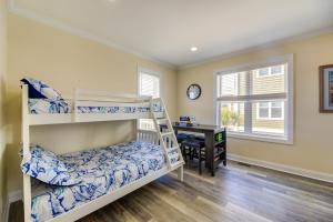 a bedroom with two bunk beds and a desk at Emerald Isle Getaway with Decks and Beach Views! in Emerald Isle