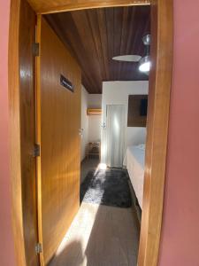 a hallway leading to a bedroom with a bed at Valle da Benção Pousada in Chapada dos Guimarães