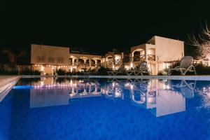 a resort with a swimming pool at night at El Colonial Departamentos in Cafayate