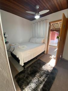 a bedroom with a bed with a ceiling fan and a rug at Valle da Benção Pousada in Chapada dos Guimarães