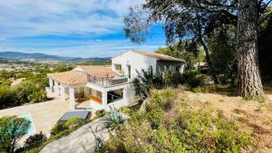 uma casa branca no topo de uma colina em Les Chenes em Sainte-Maxime