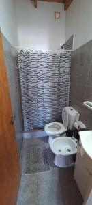 a bathroom with a toilet and a sink and a shower at Cuty Nakey in Puerto Madryn