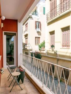 uma varanda com uma mesa e uma cadeira e um edifício em The Burton Luxury 1BR in Plaka, Athens em Atenas