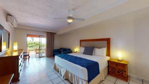 ein Hotelzimmer mit einem Bett, einem Schreibtisch und einem Zimmer in der Unterkunft Park Royal Homestay Los Tules Puerto Vallarta in Puerto Vallarta