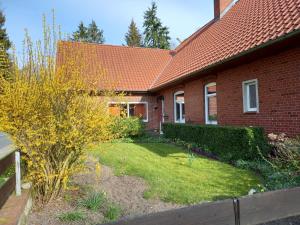 una casa de ladrillo rojo con un jardín delante de ella en Fremdenzimmer Buchholz en Groß Sehlingen