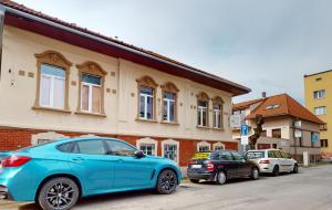 een blauwe auto geparkeerd voor een gebouw bij Villa City Park in Košice