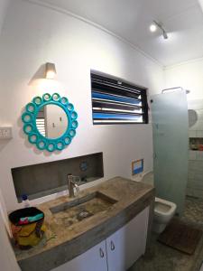 a bathroom with a sink and a mirror and a toilet at Cozy house for Kite & windsurfers (Le Morne) in Le Morne