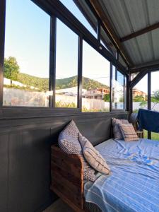 a bed in a room with large windows at Cozy house for Kite & windsurfers (Le Morne) in Le Morne