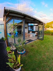 a glass house with plants in the yard at Cozy house for Kite & windsurfers (Le Morne) in Le Morne