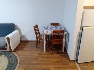 uma cozinha com uma mesa e cadeiras e um frigorífico em Apartment Dastidi em Kosovska Mitrovica