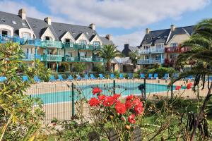 un hôtel avec une piscine en face d'un complexe dans l'établissement LocaLise au Guilvinec - A28 - Belle vue sur la mer, la piscine et le jardin - - Tout à pied, plages, port, centre, commerces, marché - Wifi inclus - Linge de lit inclus, au Guilvinec