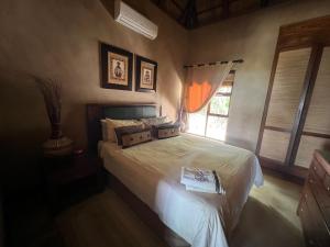 a bedroom with a bed and a window at Pumula Bush Chalet in Mabula +21 photos