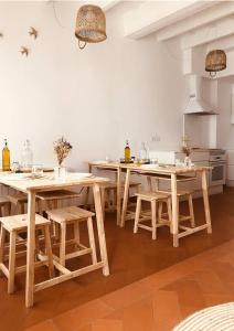 a kitchen with wooden tables and chairs in a room at MAISON HÔTEL SES PENYES in Alaior