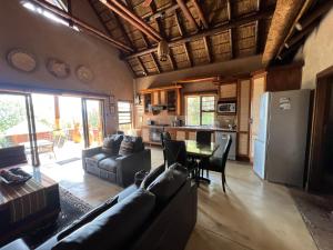 a living room with a couch and a table at Pumula Bush Chalet in Mabula