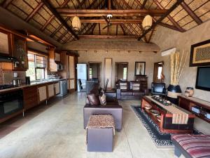 a living room with a couch and a table at Pumula Bush Chalet in Mabula