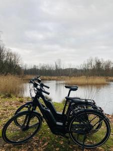 una bicicletta parcheggiata accanto a un corpo d'acqua di B&B La Miniera a Genk