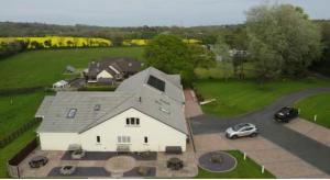 a large white house with a car parked in a driveway at Lovesgrove Country Guest House in Pembroke Dock